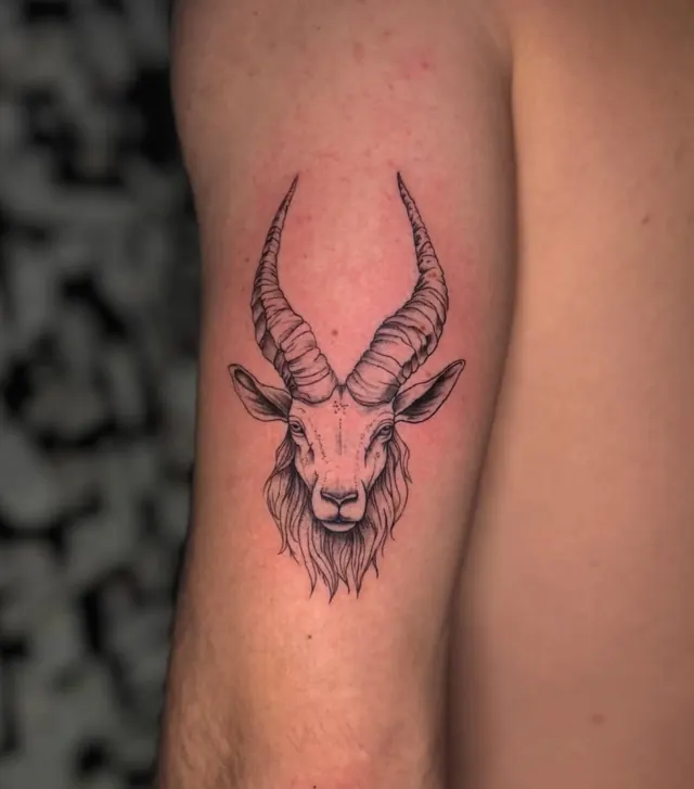 Black and grey ibex head on the upper arm